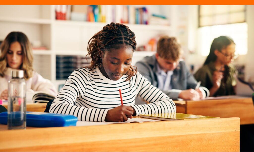Teens in classroom writing scholarship thank you notes.