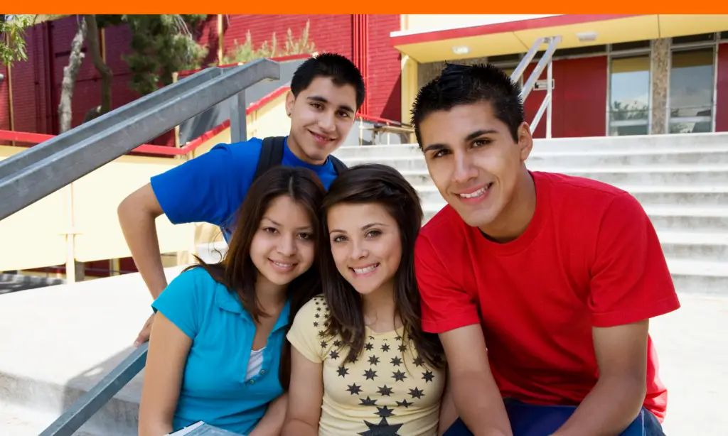 teens sitting on campus stairs celebrating rhode island scholarship approvals