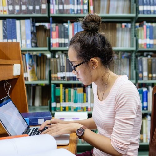 girl student studying with her laptop in a library