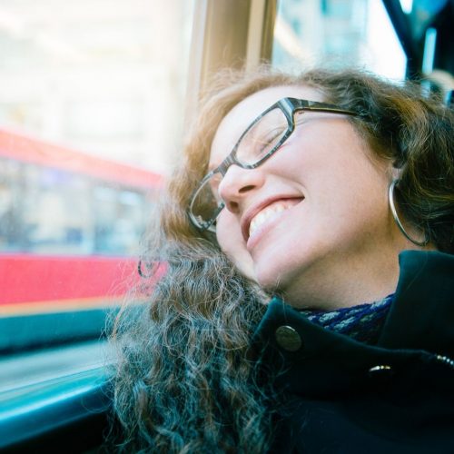 girl on the bus laughing looking outside