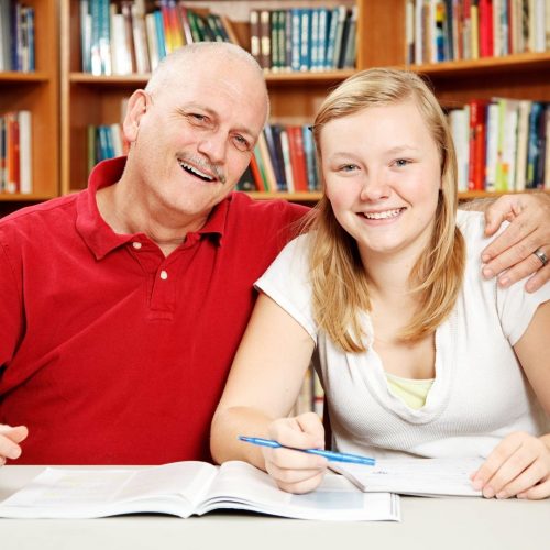 Dad and daugther posing for picture studying in the library