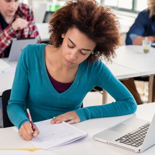 girl student writing an essay in class