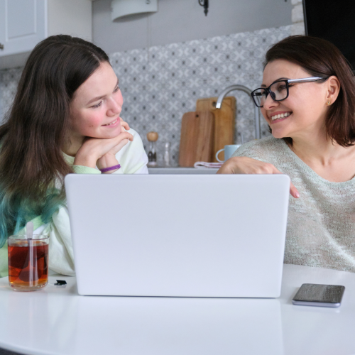 Parent and student reviewing college deferral statistics on a laptop while discussing next steps after being deferred from college.
