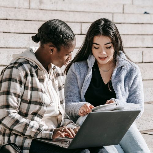 two girl students looking at laptop