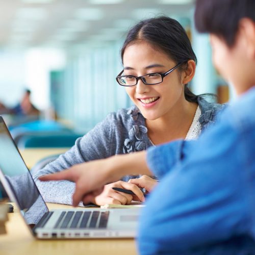 girl student writing essay in a laptop