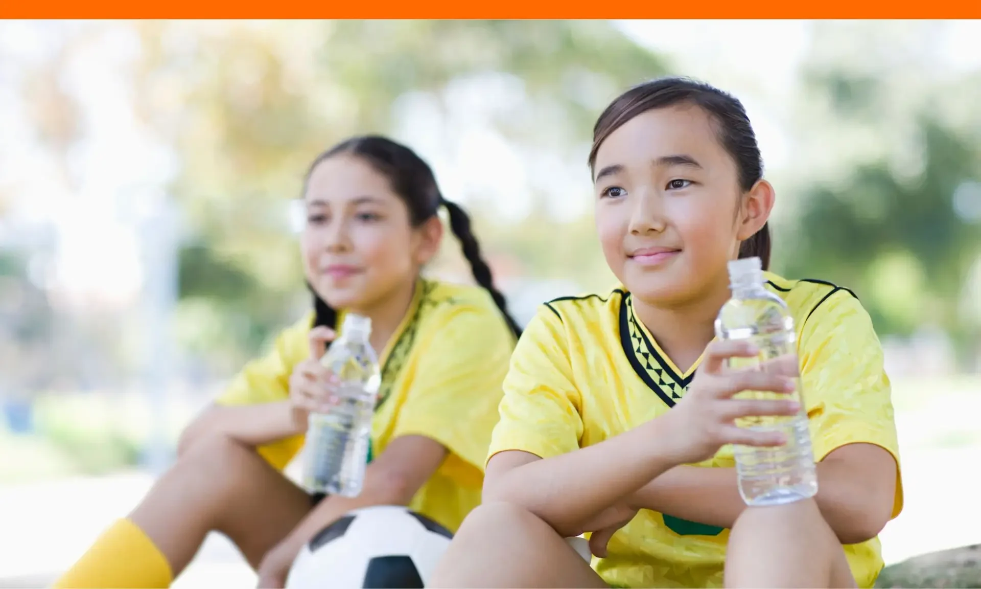 Teen girls resting while training for extracurricular activity.